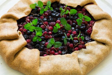 Kırmızı ve siyah kuş üzümü, yaban mersini ve rapsberries ev yapımı Galette'ye pasta. Üstten Görünüm