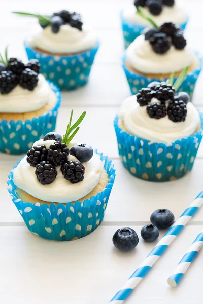 Cupcakes caseiros com cobertura, mirtilos, amoras e folhas de alecrim — Fotografia de Stock