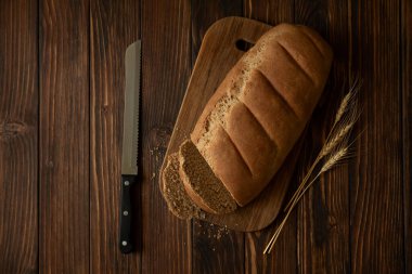 Tahta kesme tahtasının üzerinde ev yapımı çavdar ekmeği. Üst görünüm