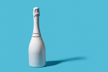 Beyaz arka planda beyaz şampanya şişesi. Yeni yıl kutlaması konsepti