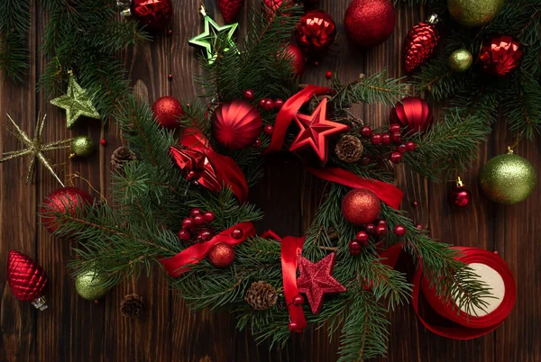 Çiçekçi eller tahta kahverengi arka planda Noel çelengi yapıyor. Üst Manzara. Yeni yıl ya da Noel kutlaması konsepti