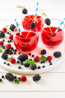 Beyaz ahşap masada ahududu ve böğürtlenli yaz içeceği. Yumuşak odak