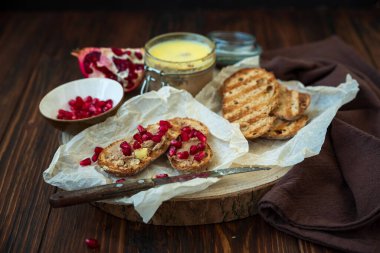 Taze ev yapımı tavuk ciğeri ekmek üzerine ezme ve kırsal ahşap arka planda nar tohumları. Yumuşak odak