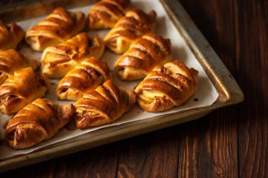 Kahverengi ahşap arka planda ev yapımı çörek, elma ve tarçın tepsisi. Üst Manzara. Yumuşak odak
