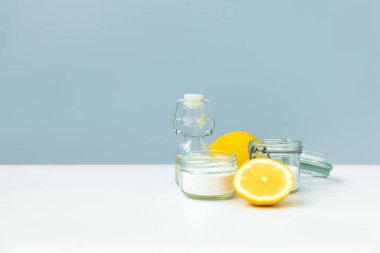 Eko temizlik ürünleri seti. Eko süngerler, limonlar, elma sirkesi, sitrik asit ve soda mavi arka planda..