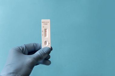 COVID-19 için hızlı test cihazı kullanılarak eldiven giyilmesi negatif test sonucu içeriyor
