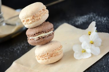 Koyu arka plan üzerinde kahve latte ile birkaç macaroons