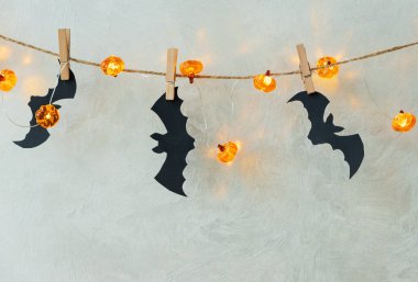 Halloween Garland with Pumpkin Lights and Bat Cutouts on Textured Wall