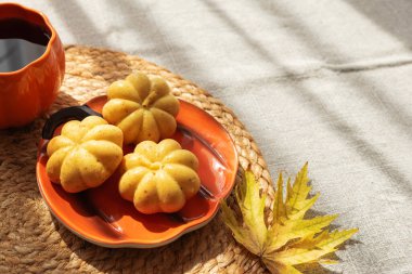 Balkabağı bardağı ve Mini keklerle örülmüş sonbahar yapraklı servis altlığı