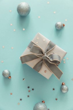 Açık Mavi Arkaplanda Noel süsleri olan Gümüş Hediye Kutusu