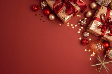 Kırmızı Kurdeleli Altın Kaplama Noel Hediyeleri ve Kırmızı Arkaplanda Süslemeler