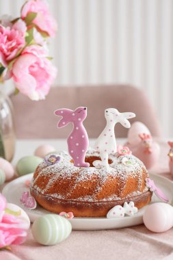 Beyaz tahta masa üzerinde tavşan şeklinde zencefilli kurabiyelerle süslenmiş geleneksel paskalya pastaları.