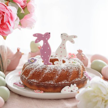 Beyaz tahta masa üzerinde tavşan şeklinde zencefilli kurabiyelerle süslenmiş geleneksel paskalya pastaları.