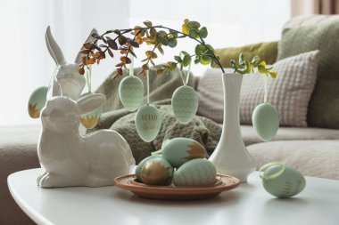 Sıcak Paskalya Salonu Dekoru Tavşan figürleri ve Beyaz Masada Asılmış Yumurtalar