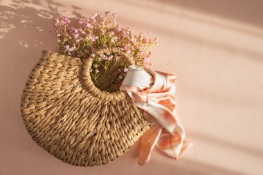 İpek Fular ve Çiçeklerle örülmüş Hasır El Çantası. Şeftali Arkaplanda Zarif Yaz Modaya Uygulaması