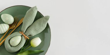 Tavşan peçetesi, süslü yumurta ve lalelerle Paskalya Sofrası. Şenlikli Bahar Düzenlemesi