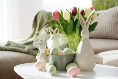 Oturma odası Paskalya yumurtalarını tavşan figürleri ve lalelerle süslüyor. Sıcak Bahar Tatili Düzenlemesi