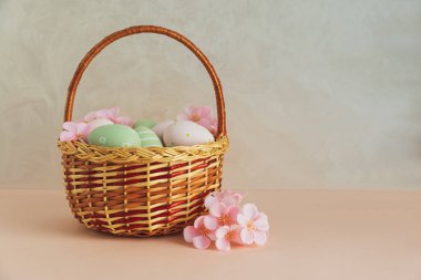 Pastel Yumurta ve Çiçekli Hasır Paskalya Sepeti. Yumuşak Bahar Dekorasyonu