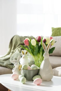 Oturma odası Paskalya yumurtalarını tavşan figürleri ve lalelerle süslüyor. Sıcak Bahar Tatili Düzenlemesi