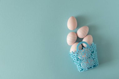 Mavi Arkaplanda Pastel Pembe Paskalya Yumurtaları 'nın olduğu sepet. En Küçük Şenlik Kompozisyonu