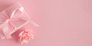 Pembe hediye kutusu ve güller. Romantik Sevgililer Günü ya da Anneler Günü Yumuşak Pembe Arkaplanda Düz Yatış