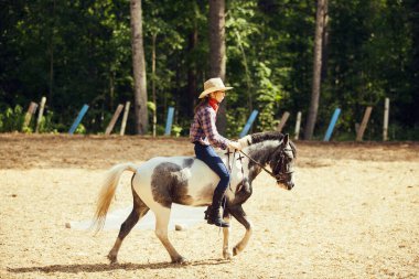 At sırtındaki genç kız. Binici bir kız. Şapkalı kovboy kız..