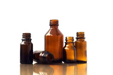 Beyaz arka planda koyu kahverengi şişeler. Küçük boş şişeler
