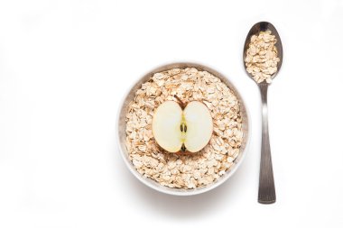 Elma bir beyaz tabak ve kaşık yulaf ezmesi