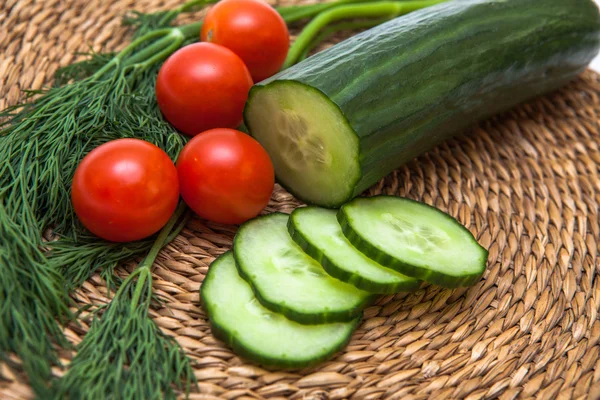 domates ve tahta bir tahta üzerinde dereotu ile dilimlenmiş salatalık