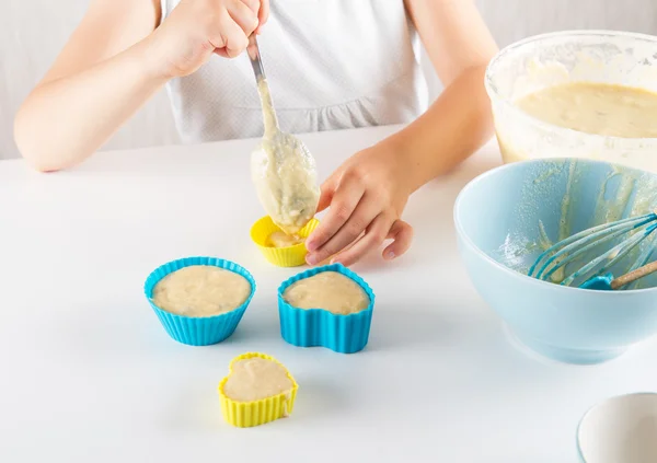 Enfant met la pâte dans les boîtes de muffins — Photo