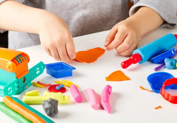 Mãos de criança com argila colorida — Fotografia de Stock