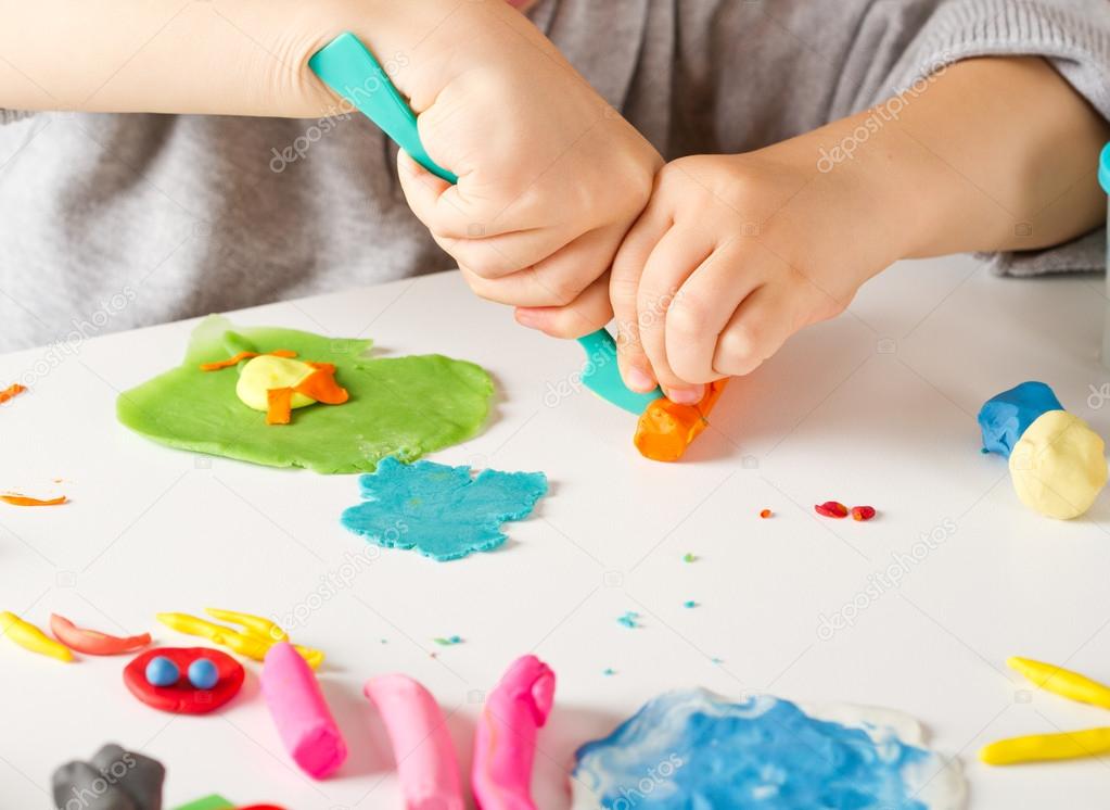 Child hands  with colorful clay
