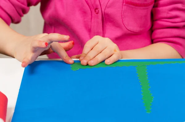 Niño hace aplicación de papel de color —  Fotos de Stock