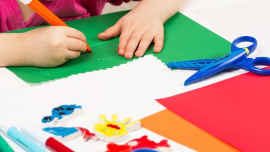 Çocuk renkli kağıttan uygulama yapar