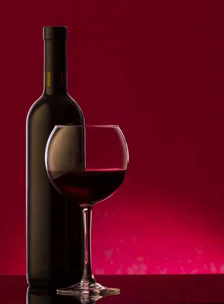 Ένα γυαλί και μπουκάλι κόκκινο κρασί — Φωτογραφία Αρχείου