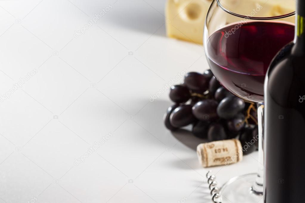 Grape and cheese with a bottle and glass of red wine