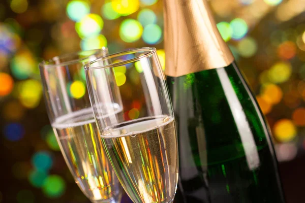 Par glas champagne och champagne flaskan på bokeh bakgrund — Stockfoto