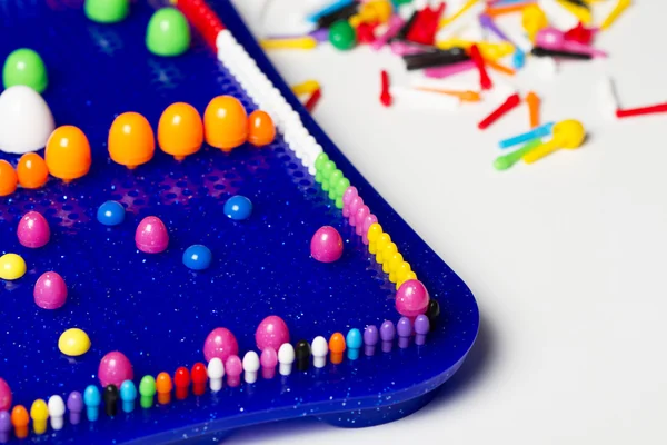 Las manos del niño para construir un mosaico de plástico multicolor pin —  Fotos de Stock