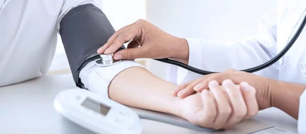 Doktor kan basıncını ölçerek hastayı muayene ederek, sonuçları sunarak ve tedavi yöntemi, sağlık ve tıbbi konsept önererek ölçüyor..