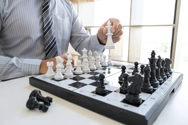 Businessman playing chess and thinking strategy about crash overthrow the opposite team and development analysis for win and successful.