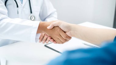 Doktor hastane ofisinde hastalarıyla tokalaşıyor, doktorla konuşup hastaya iyi sonuçlar hakkında yakın çekim yapıyor ve sağlık ve tıp hakkında tavsiyelerde bulunuyor.