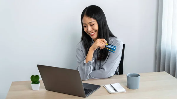 Mujer Asiática Joven Sosteniendo Tarjeta Crédito Mirando Ordenador Portátil Para — Foto de Stock