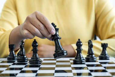 Satranç oynayan ve düşme stratejisi düşünen bir kadın karşı takımı devirir ve başarılı olmak için geliştirme analizi yapar..