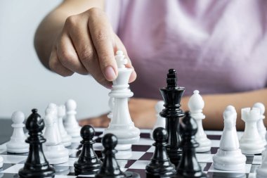 Satranç oynayan ve düşme stratejisi düşünen bir kadın karşı takımı devirir ve başarılı olmak için geliştirme analizi yapar..
