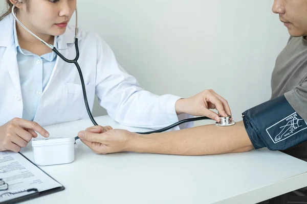 Doctor is checking blood pressure for the patient and using stethoscope to listening heartbeat while diagnosing disease and illness symptoms of patient at her clinic