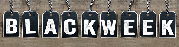 Black wooden hang tag with message Black Week on weathered wood background