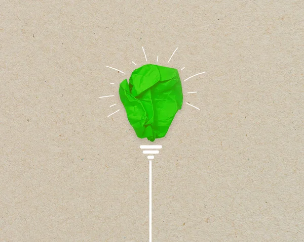 Green paper light bulb metaphor for recycling and green renewable energy green climate concept on brown recycled paper
