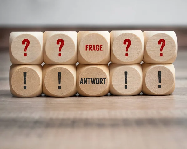 Cubes and dice with the germans words for question and answer - frage und antwort on wooden background