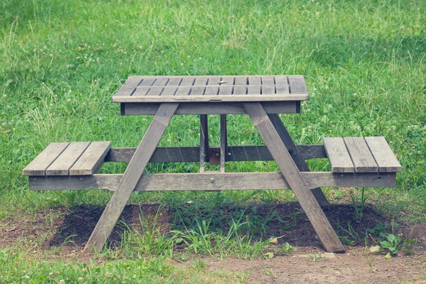 Деревянная скамейка в зеленом парке — стоковое фото