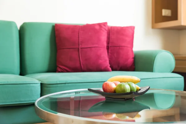 Fresh fruit and green sofa — Stock Photo, Image